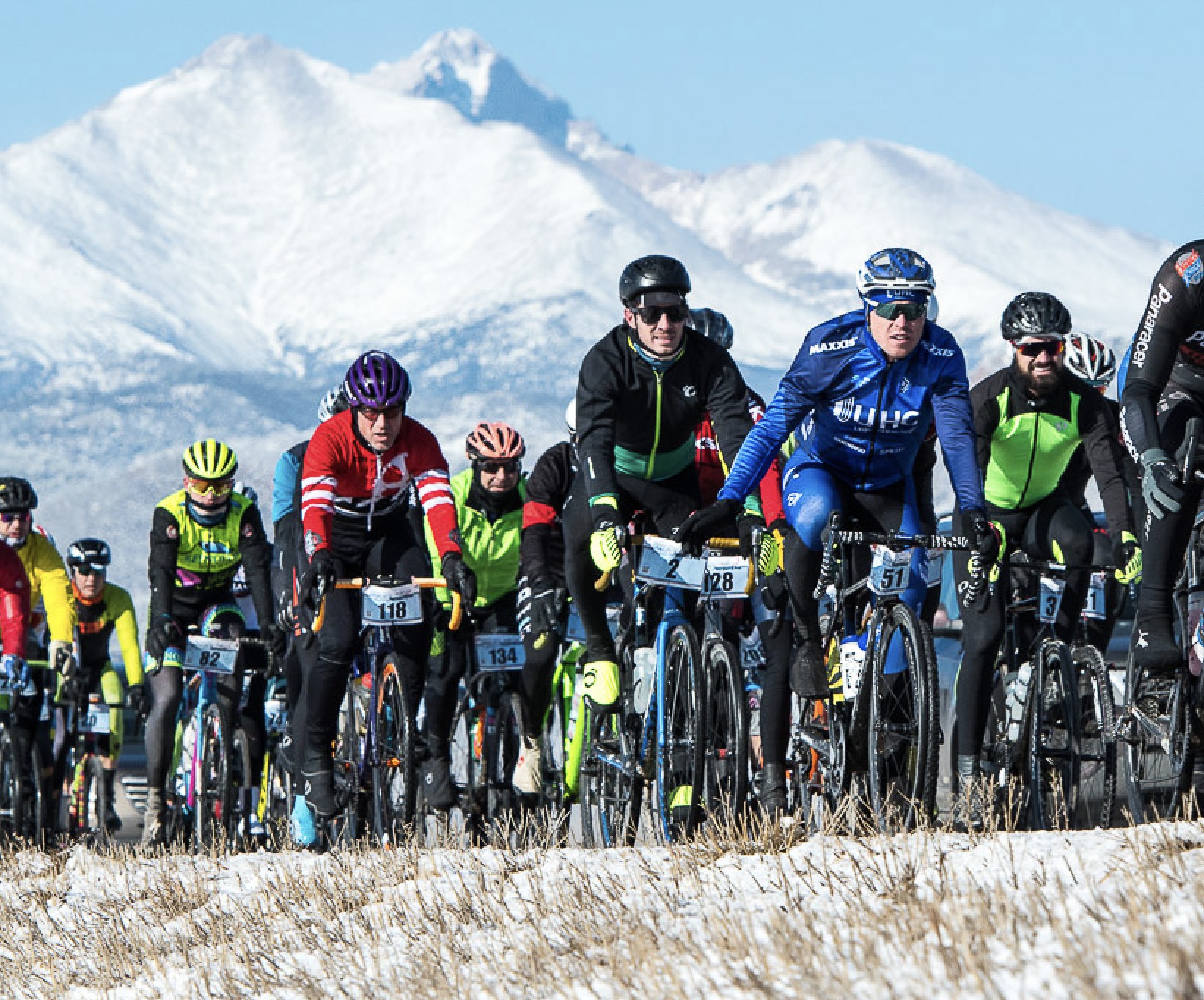 A group of cyclists riding together on a Colorado winter road