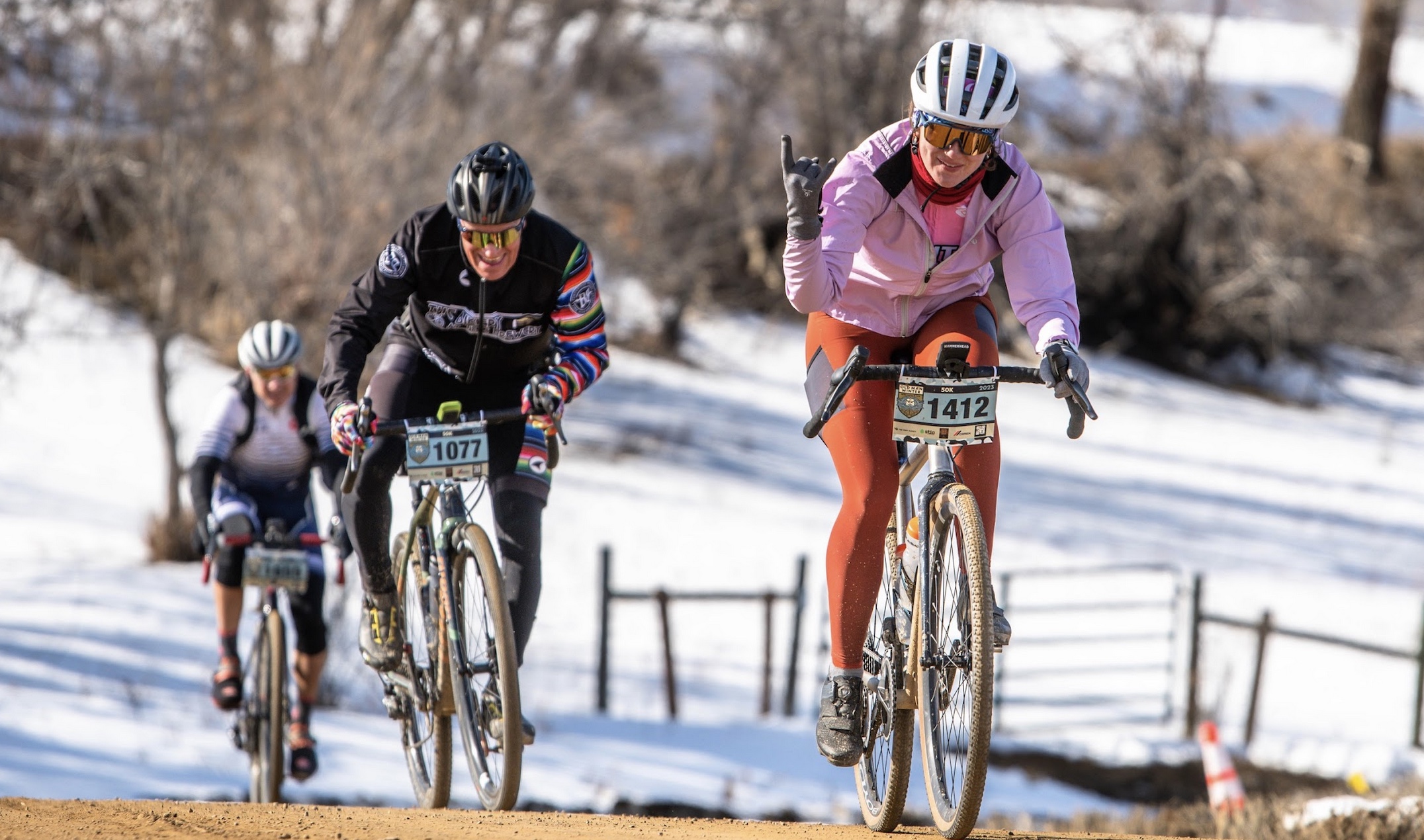 Cyclists riding beside a sunlit Colorado canyon wall