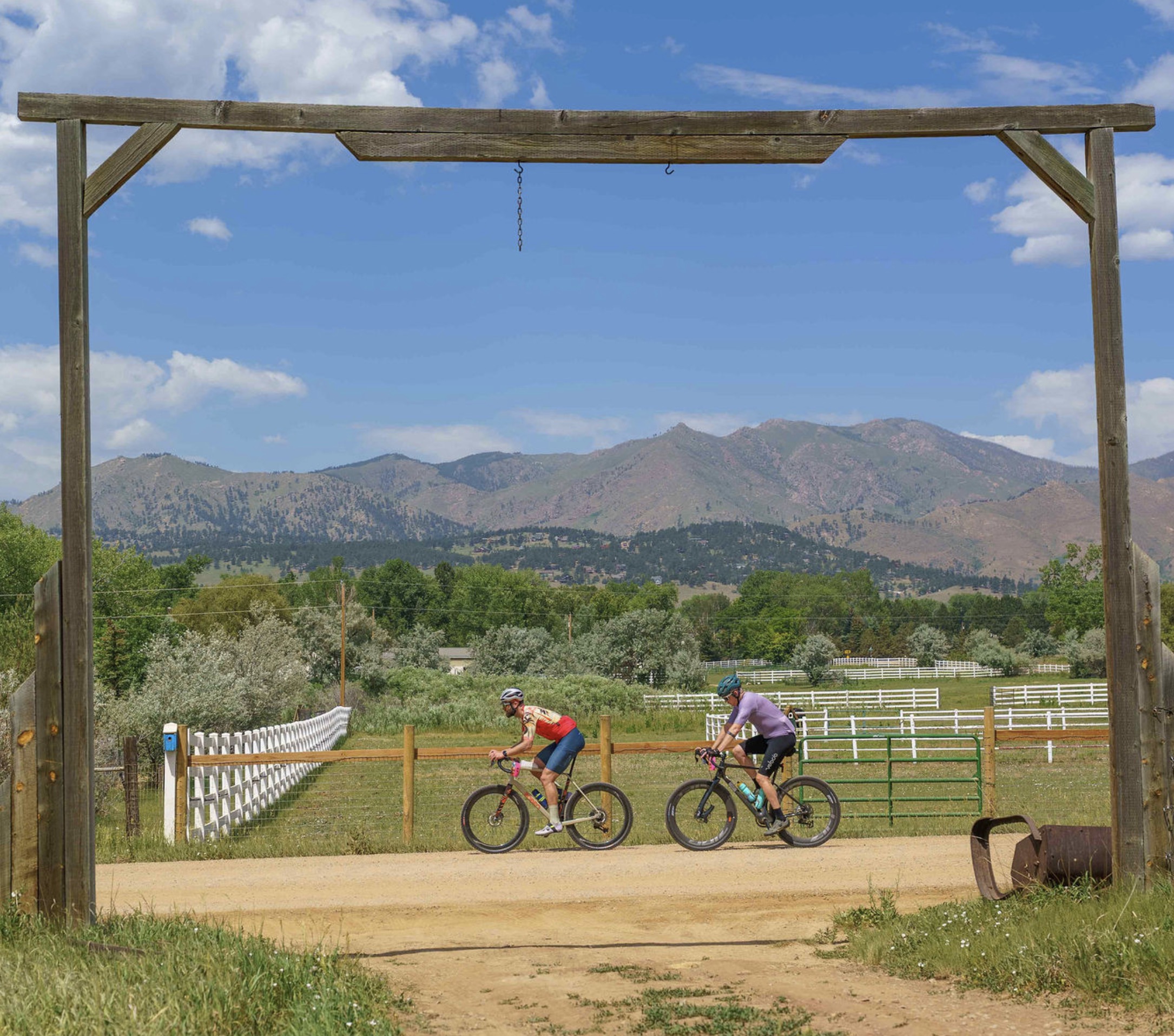 Gravel road with a painted sunflower post and mountain views