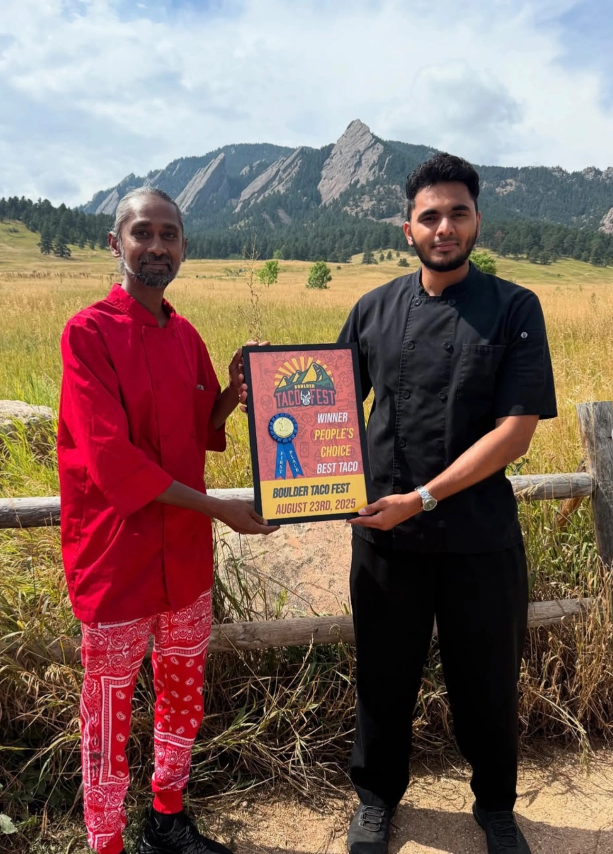 Two men holding a Boulder Taco Fest People's Choice Best Taco winner sign on August 23rd, 2025